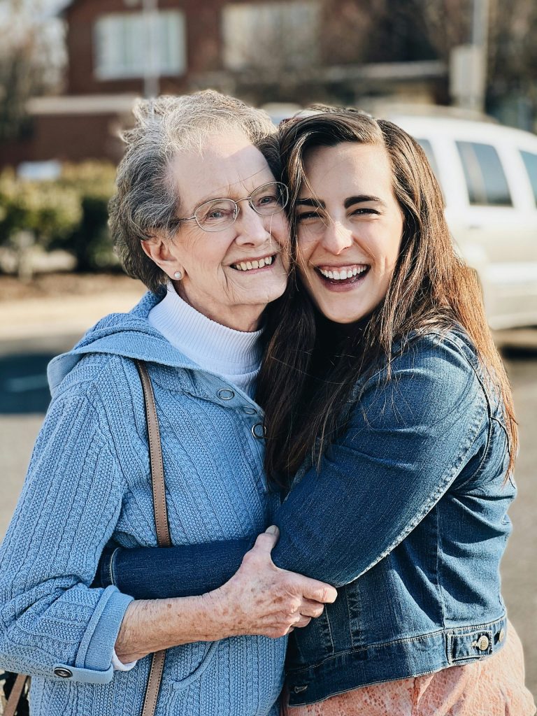 two women hugging each other in a parking lot